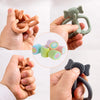 Hands hold various silicone teething toys including an elephant, a ring, and small silicone tubes.