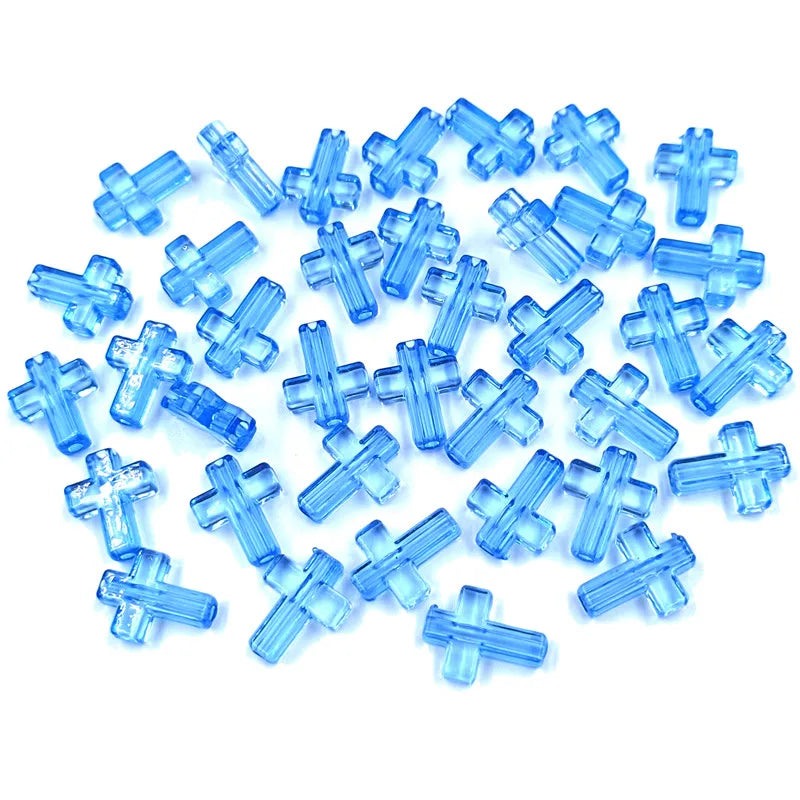 A pile of small, translucent blue acrylic cross beads for jewelry making.