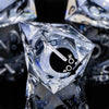 A close-up of a clear, diamond-shaped resin dice set featuring a black cat silhouette.