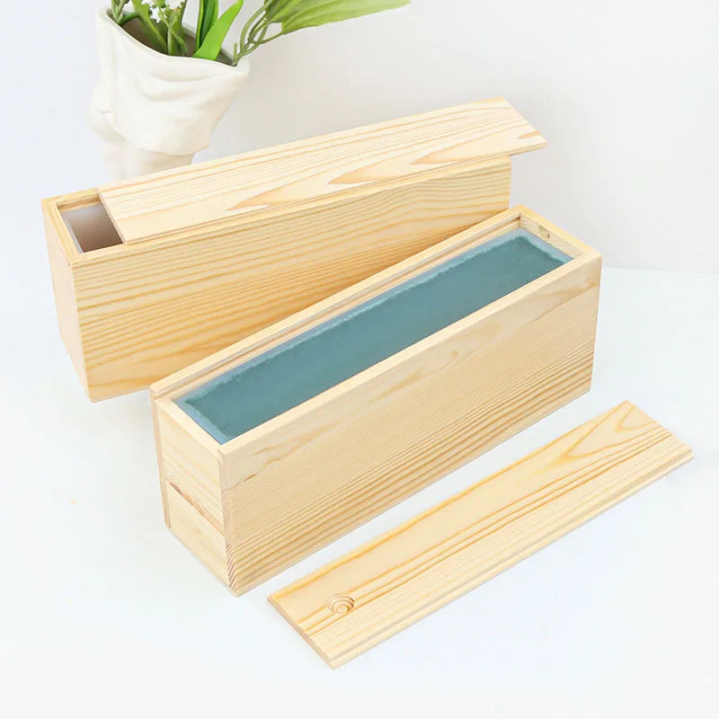 A wooden box and lid for a silicone rectangle soap mold is shown on a white surface.