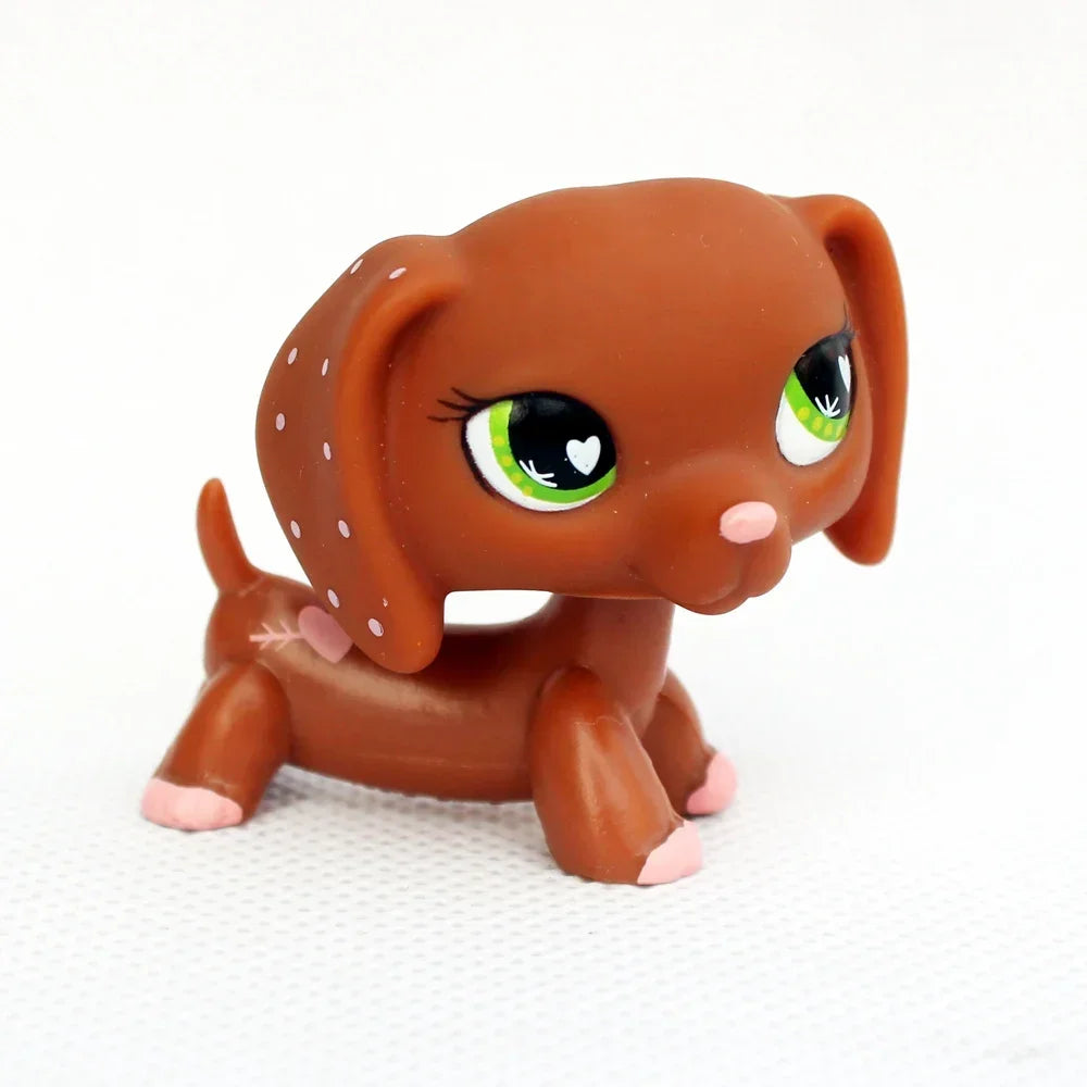 A small, brown dachshund bobblehead figurine with large green eyes and pink accents.