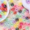 Collection de perles de séparation en acrylique facettées colorées, roses, vertes, jaunes et violettes.