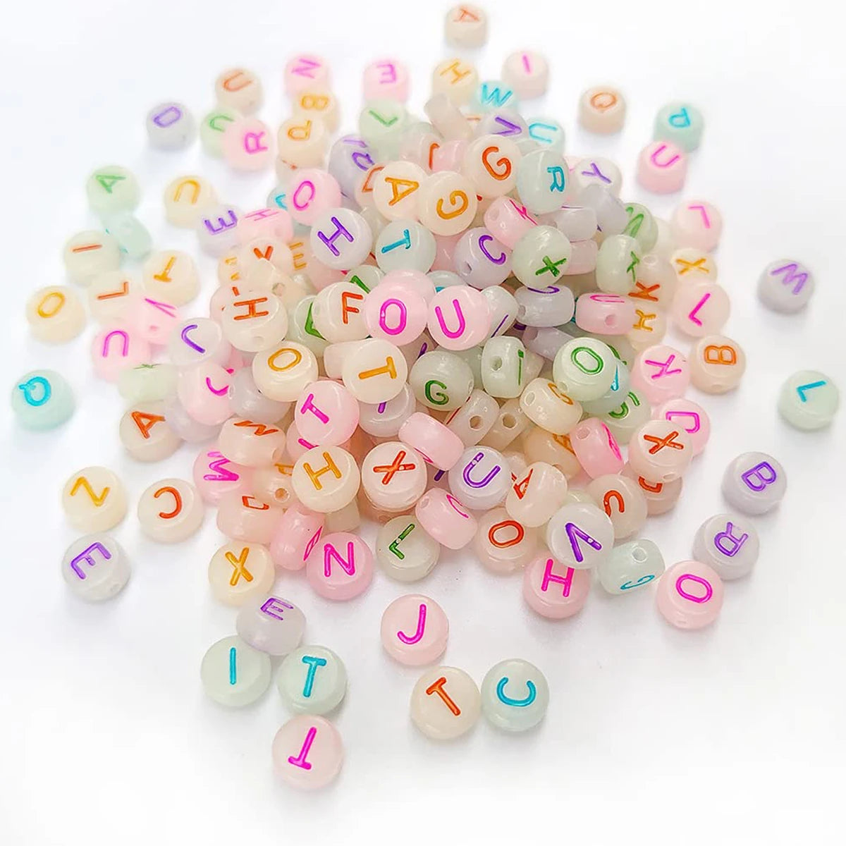 A pile of round acrylic alphabet beads in various pastel colors and letters for jewelry making
