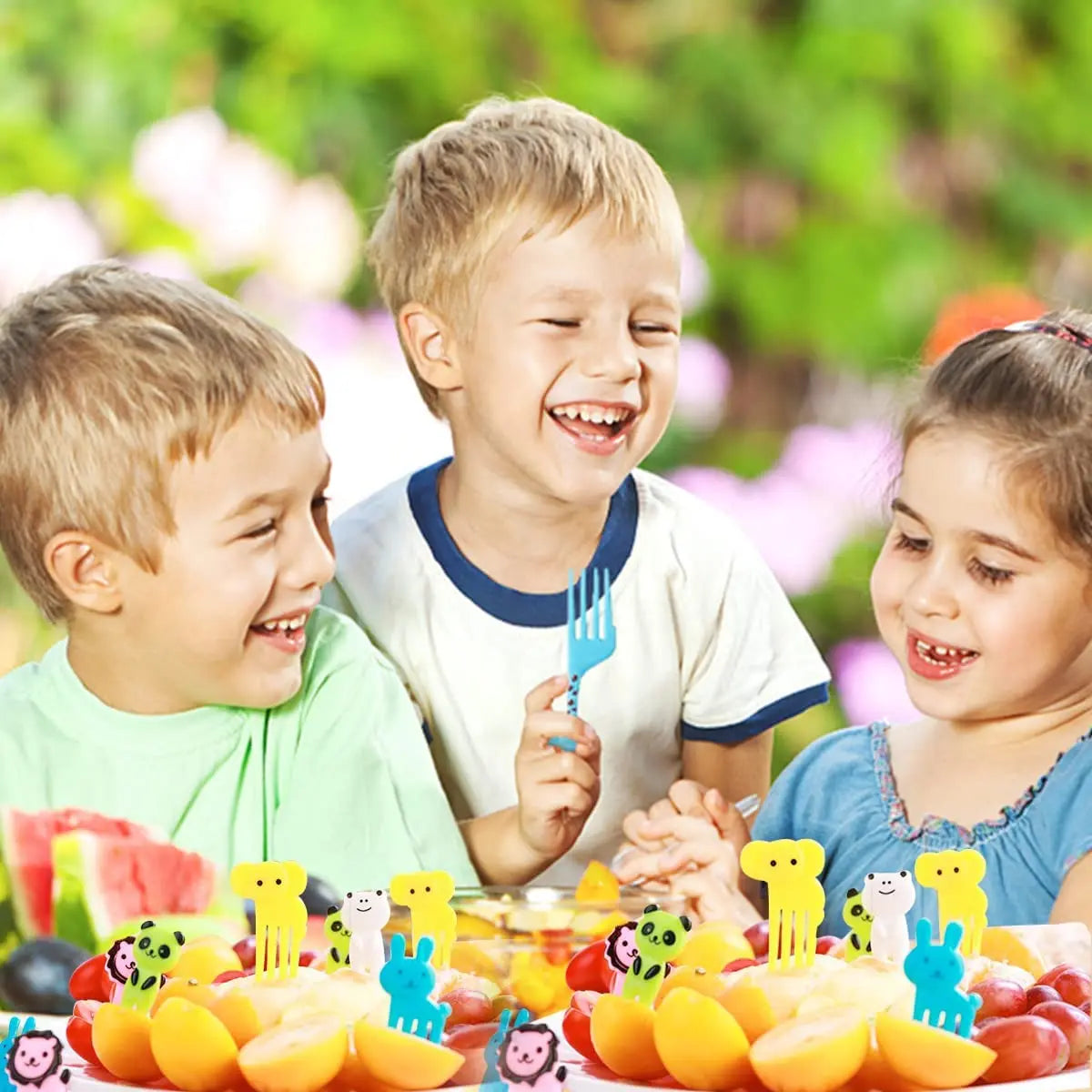 A set of kawaii mini fruit forks and various colorful fruits displayed in a bright outdoor setting.