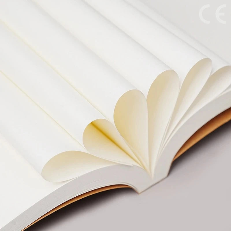 A close-up view of a Kraft paper DIY notebook with blank pages, showing the layered paper texture and soft light.