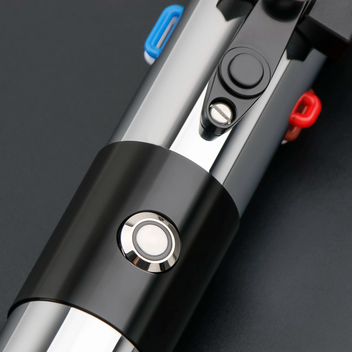 A close-up view of a Darth Vader Neopixel lightsaber with a black and silver hilt and red accents.