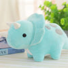 A light blue soft plush toy of a triceratops dinosaur resting on a white surface.