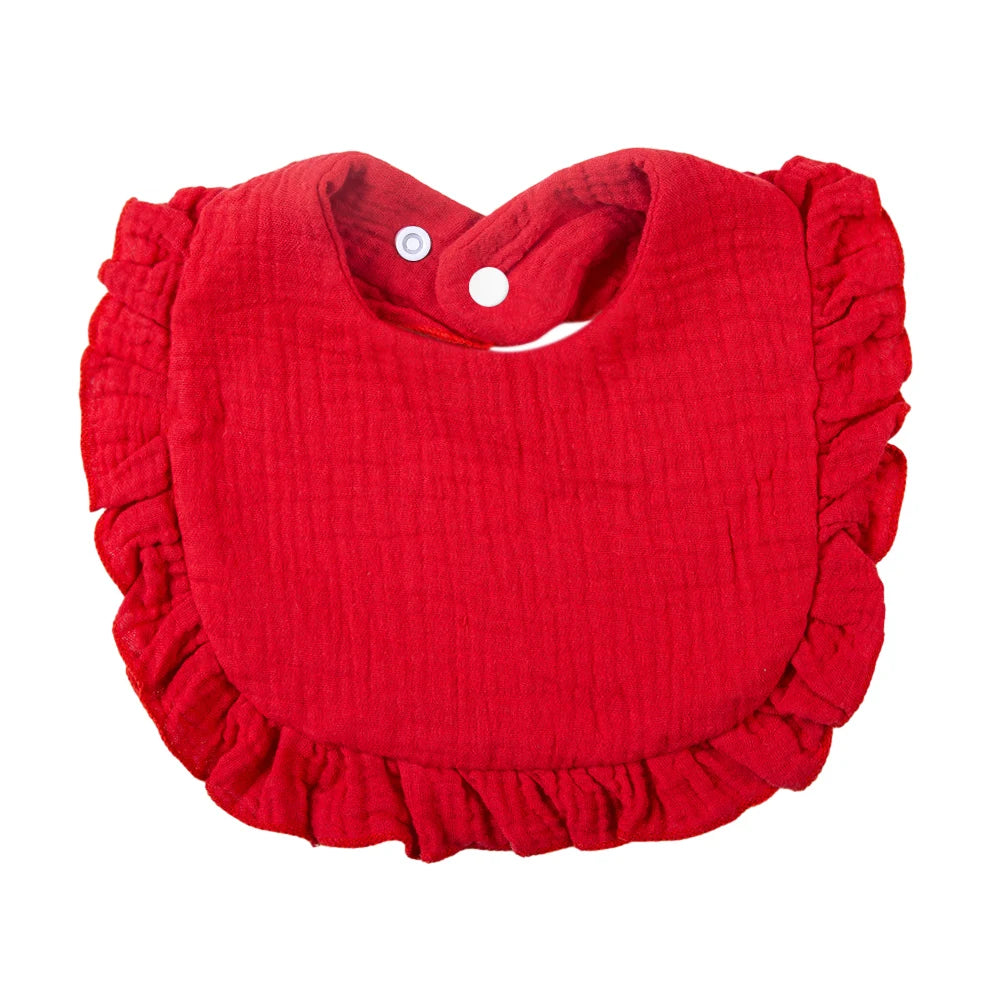 A red ruffled muslin cotton baby bib with an adjustable snap closure.