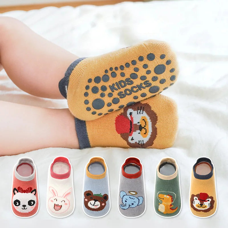 A collection of six kids cotton cartoon animal socks in various colors and designs laid out on a white surface.