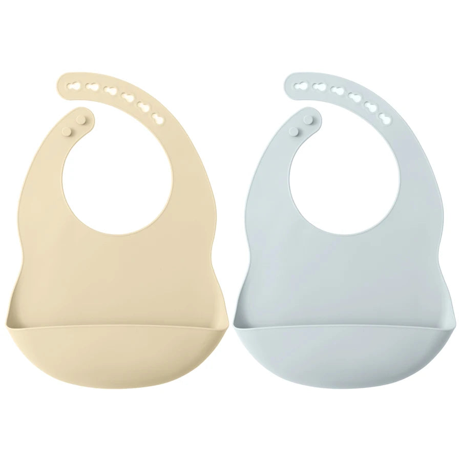 A pair of light beige and light blue waterproof silicone baby bibs with adjustable necks.