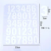 A sheet of DIY iron-on heat transfer patches showing a grid of numbers and text with a scale marker.