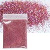 A sealed bag of holographic pink glitter powder scattered across a white background.