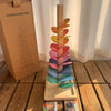 A wooden sensory music tree with a marble run featuring colorful, stacked, translucent plastic pieces.