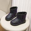 A pair of purple glitter snow boots with faux fur lining displayed on a white surface.