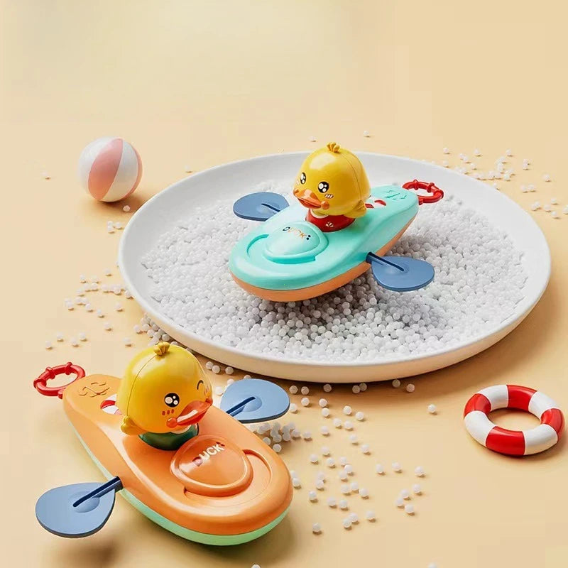 Gelbes mechanisches Fischbadspielzeug auf weißen Kieselsteinen in hellem Beige.