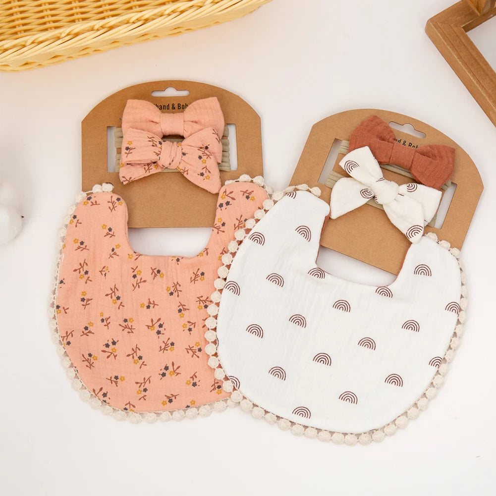 A set of three baby flower bibs and a headband featuring pink, white, and natural fabric textures.