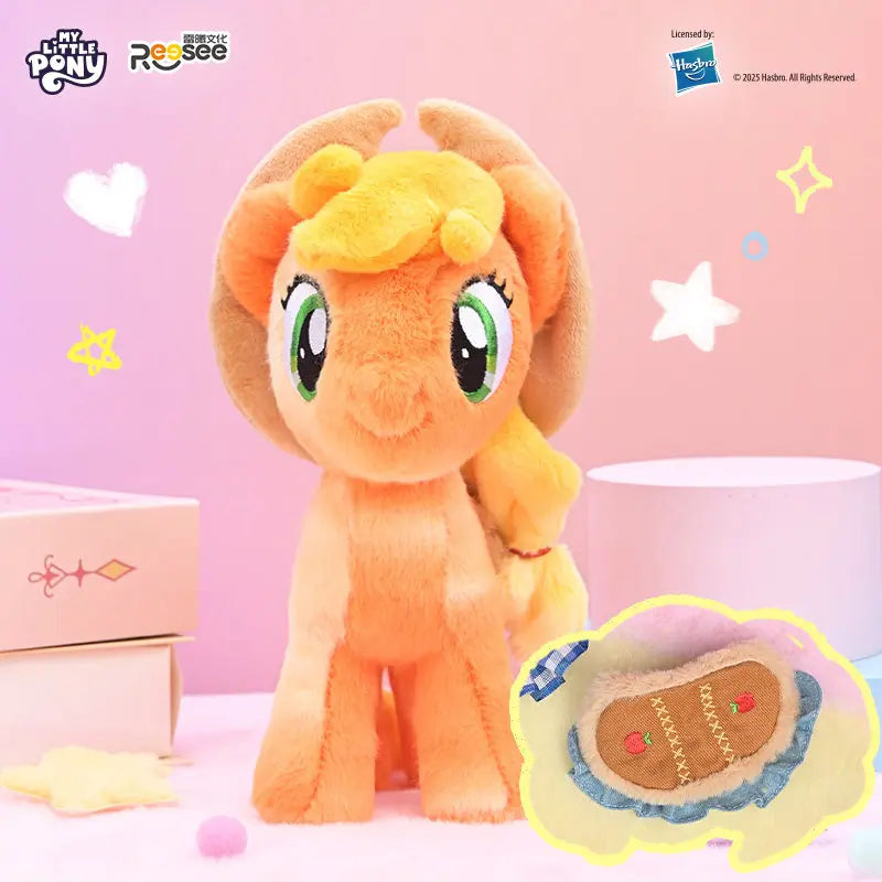 An orange My Little Pony plush pendant with a detachable saddle is displayed on a pink surface.