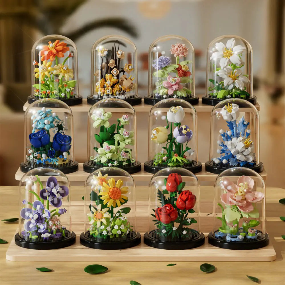 A display of various eternal rose flower kits in glass domes arranged on a wooden tray.