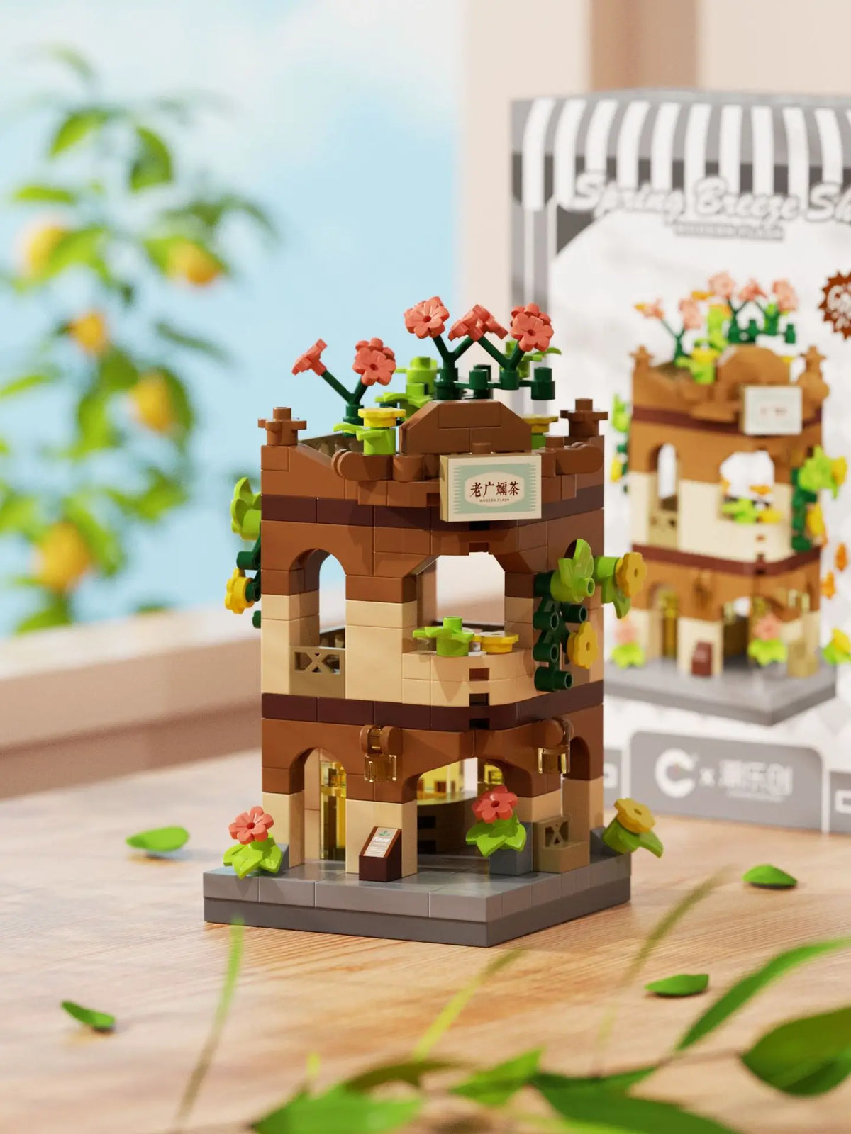 A miniature building set depicting a rustic brown wooden tower with pink flowers and green foliage.