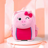 A pink pig-themed backpack with a bow, sitting on a white circular stand.