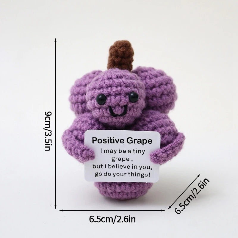 A handmade crochet pocket hug doll in purple with a brown top, featuring an inspirational slogan.