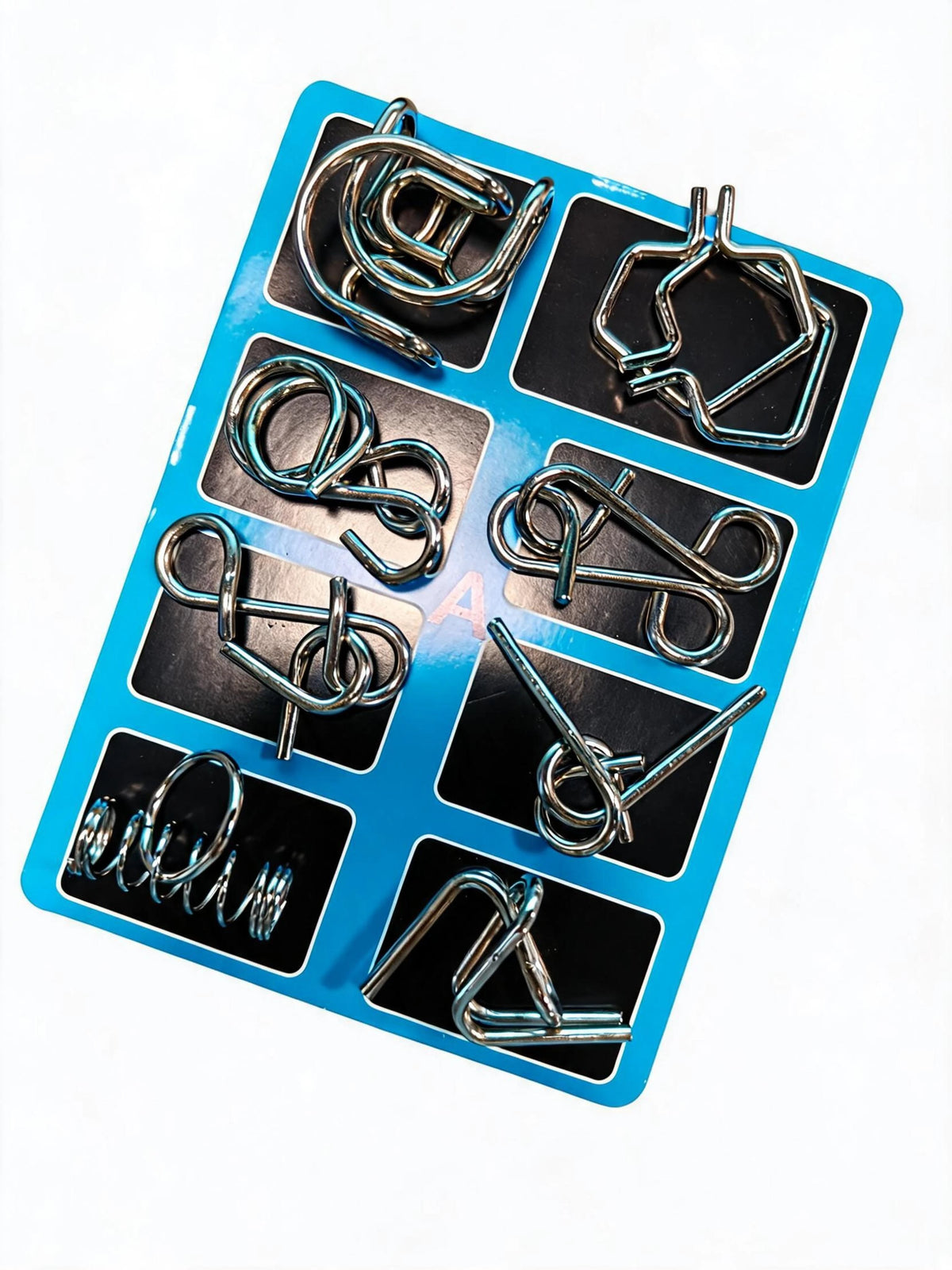 A blue plastic tray holding eight metal brain teaser puzzle pieces.