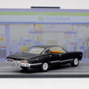 A black diecast model of a 1967 Chevrolet Impala with a yellow interior, displayed on a gray surface.