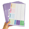 A hand holds a stack of purple place value learning posters for kids with dry erase math charts.