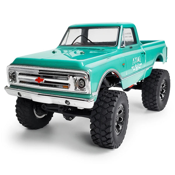 A teal Ford pickup truck model with large off-road tires and chrome grille.