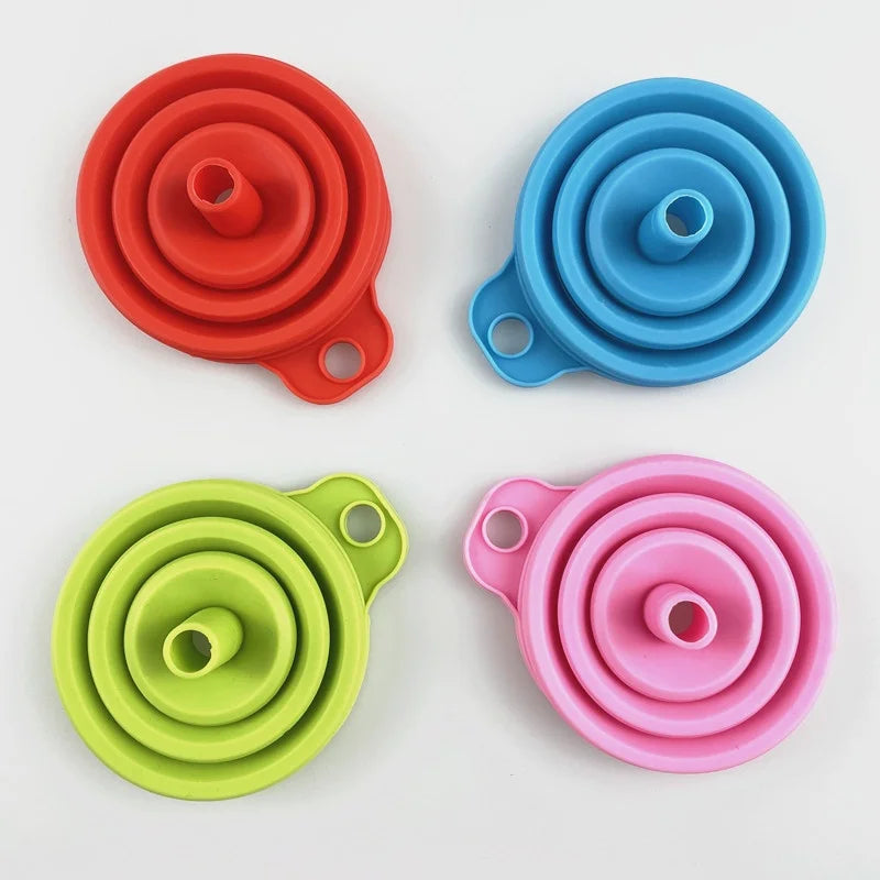 A set of three colorful silicone funnels in orange, blue, and pink, designed for kitchen and travel use.