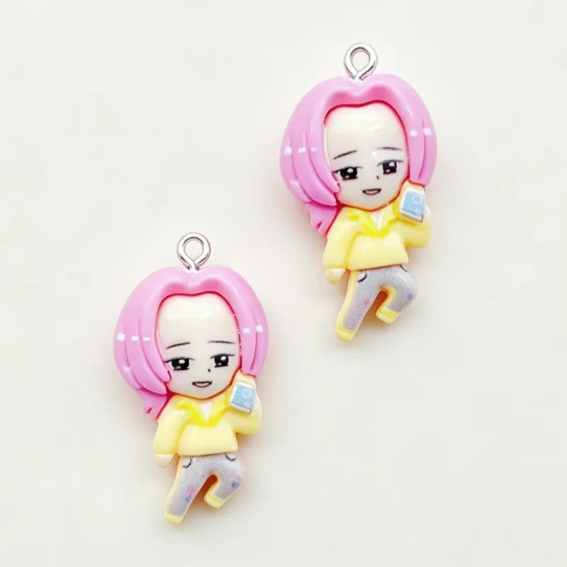 A set of 11 cartoon resin pendant charms featuring a girl with pink hair and yellow clothing.