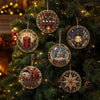 A close-up of various ornate diamond painting ornaments hanging on a green Christmas tree.