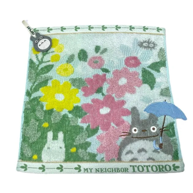 A soft stuffed animal featuring a cat character surrounded by pink and green floral patterns.