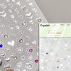 Silver heart-shaped nail art stickers with various colored accents on a white background