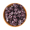 A pile of pink and black leopard print silicone beads in a wooden bowl.