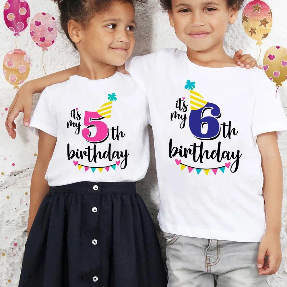 Two children wearing white t-shirts celebrating their 5th and 6th birthdays with colorful bunting