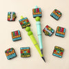 A collection of colorful silicone bingo-themed beads and a pen are arranged on a light background.