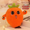 An orange carrot style plush toy with large eyes and a green leafy top sits on a white surface.