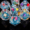 A collection of liquid core polyhedral dice in various colors and shapes, including pink, yellow, purple, and blue.