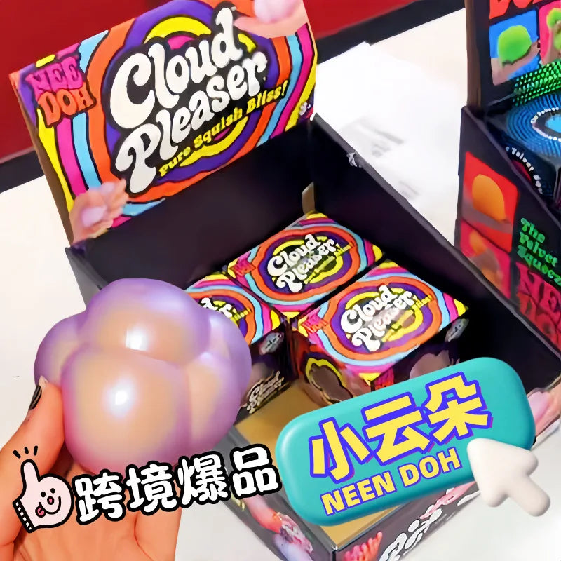 A hand holds a purple squishy cube product inside its packaging box.