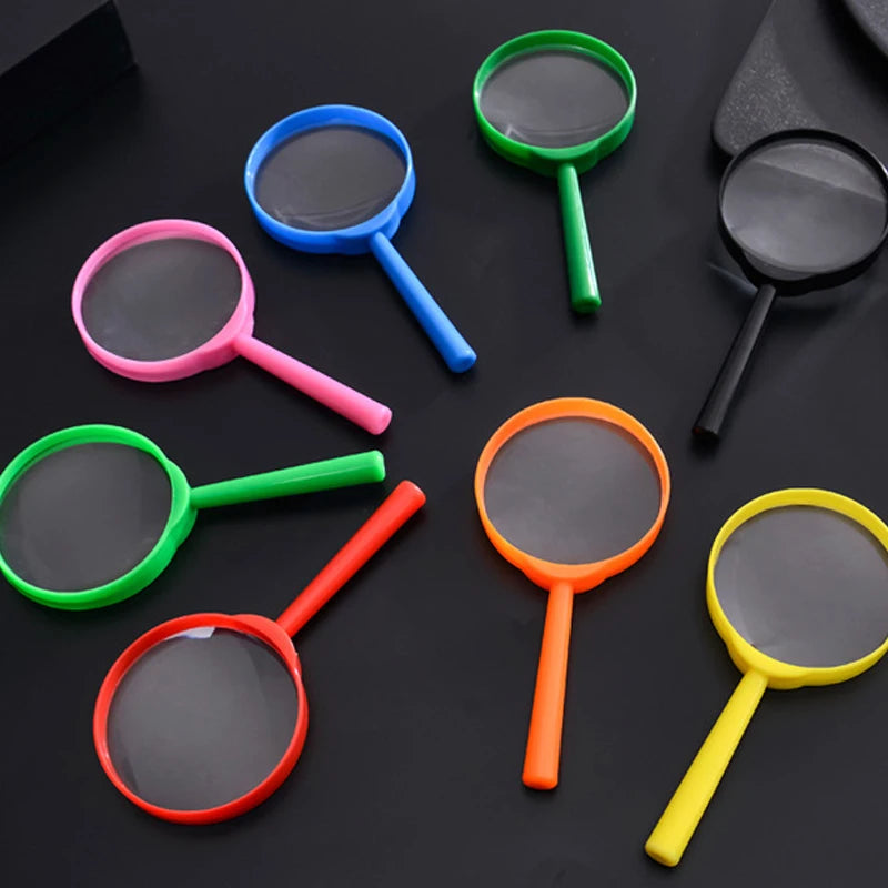 A collection of colorful plastic magnifying glasses with various colored handles and lenses on a dark surface.