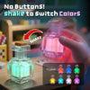 A hand shakes a clear plastic light decoration to switch between seven different LED colors.