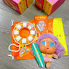 A blind box featuring a Crybaby Vacation Mode On vinyl figure and accessories on an orange background.