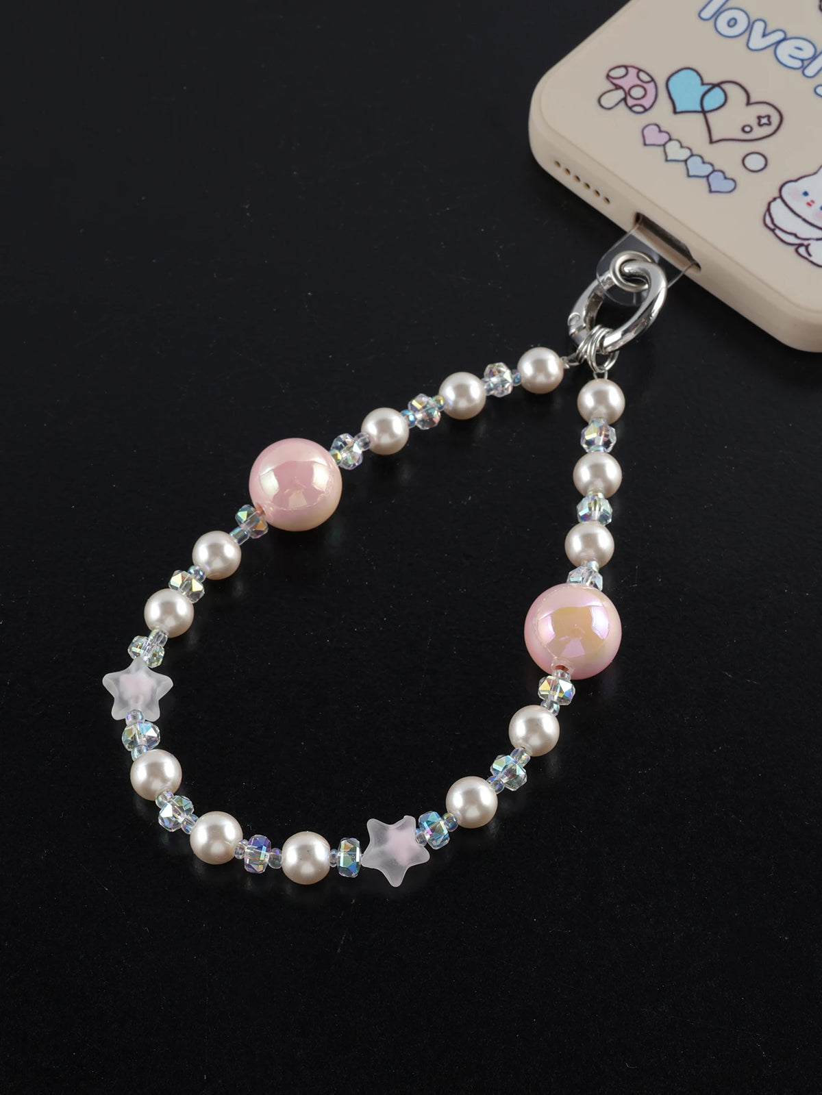 A necklace featuring pink and white pearl crystals and star charms attached to a bag clip.