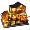 A detailed wooden dollhouse with furniture and interior LED lighting, featuring a pitched roof and decorative elements.