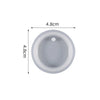 A round, light gray silicone mold with a central depression used for resin jewelry making.