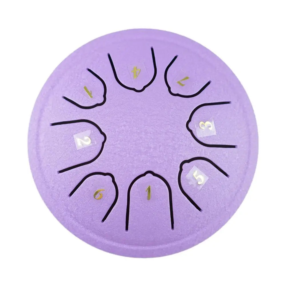 A purple steel tongue drum with black tuning pegs and numbered markings on the surface.