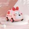 A pink rabbit ambulance toy car with a white face and red accents is displayed on a white stand.