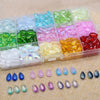 A collection of colorful water drop Czech glass beads in various shades and sizes arranged in small plastic compartments.