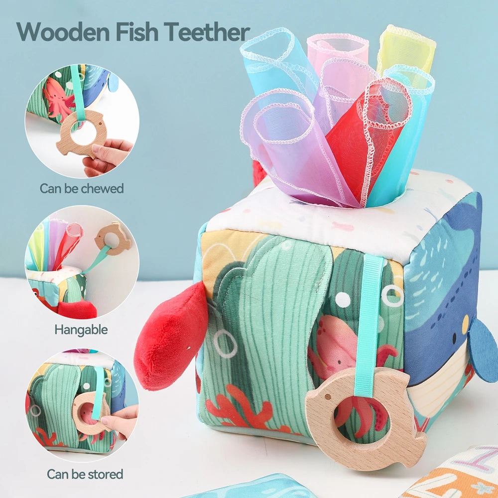 Wooden fish teether toy with colorful tissue inserts and an ocean-themed box for baby